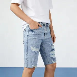 Vista di dettaglio di pantaloncini di jeans da uomo chiari con strappi e vestibilità trendy.