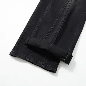 Gros plan sur les détails du jean stretch noir pour homme avec des coutures verticales.
