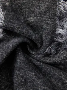 Detailed view of dark grey stone washed denim jacket fabric showing rugged distressed texture.