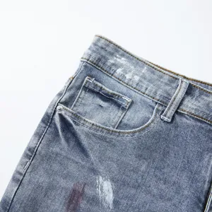 Primo piano dettagliato di pantaloncini in denim elasticizzato da uomo con macchie d'inchiostro.