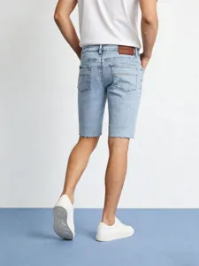 Primo piano della parte posteriore di pantaloncini in denim azzurro da uomo con toppa.