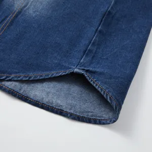 Close up detail shot of mens casual blue denim shirt hem, showing fine yellow contrast stitching.