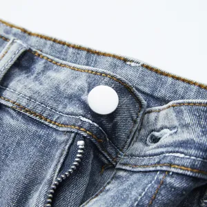 Primo piano sui dettagli della cintura dei pantaloncini in denim con bottoni e cerniera.