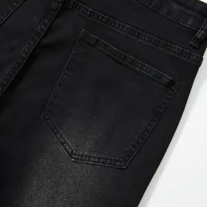Gros plan sur la poche arrière d'un jean noir, avec des coutures solides et un tissu denim.