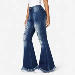 Side view detail of dark blue distressed flare jeans with stylish frayed raw hems.