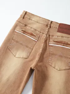 Dettaglio in primo piano della tasca posteriore di jeans in denim elasticizzato marrone vintage.
