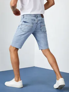 Pantaloncini di jeans azzurri uomo dettaglio retro, shorts estivi strappati elasticizzati.
