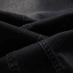 Gros plan sur la texture du tissu denim noir montrant un tissage clair et de belles coutures.