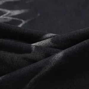 Vista dettagliata del tessuto in denim nero slavato, con trama unica e materiale elasticizzato.