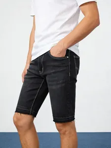 Gedetailleerd overzicht van zwarte stretch denim korte broek voor heren met contraststiksels.