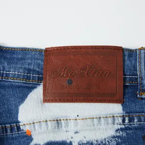 Primo piano dettagliato di pantaloncini in denim da uomo con etichetta in pelle e tessuto.
