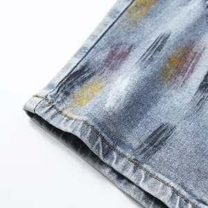 Primo piano di pantaloncini in denim estivi da uomo con stampa schizzi, orlo e dettagli.