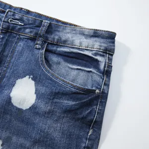 Men's stretch denim shorts detail showing trendy blue washed fabric with white paint.