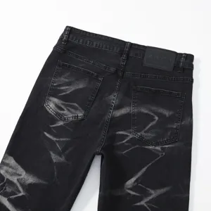 Dettaglio jeans uomo lavaggio tie-dye, pantaloni denim dritti larghi neri con toppa.