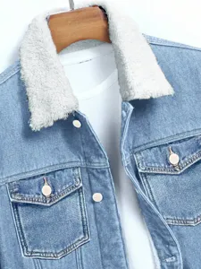 Detalle de chaqueta vaquera forrada de invierno con tela azul lavada y cuello de borreguito.