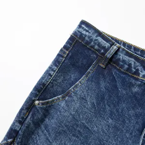 Gros plan détaillé de la poche de jeans bleu foncé délavés avec des coutures jaunes contrastées.