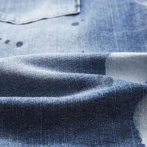Detailed view of men's summer stretch denim shorts featuring trendy paint splatter texture.
