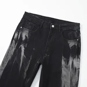 Detail shot of men's black washed denim jeans featuring unique tie-dye bleach pattern and pockets.