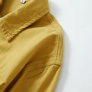 Detalle del cuello de camisa vaquera de algodón amarillo para hombre, top casual con talla M.