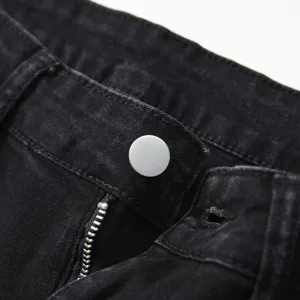 Close up of men black denim jeans waistband button and zipper detail showing fine craftsmanship.