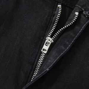Detailed view of men's black stretch denim jeans zipper fly, durable metal hardware and clean stitching.