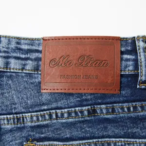 Vue détaillée de l'écusson en cuir au dos, mettant en valeur la texture du tissu denim lavé.