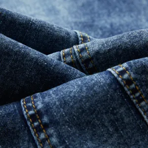 Gros plan detaille de tissu en denim lave bleu avec des coutures jaunes de haute qualite.