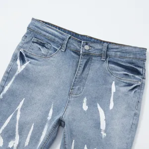 Dettaglio pantaloncini in denim uomo, motivo con schizzi di vernice bianca, stile casual estivo
