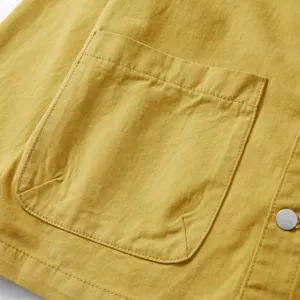 Detalle de bolsillo de camisa casual para hombre en algodón resistente con botón a presión.