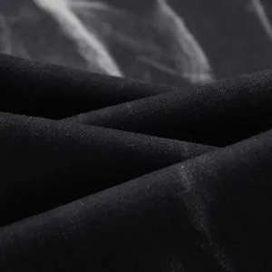 Close-up fabric detail of black washed stretch denim jeans, showing soft texture and weave.