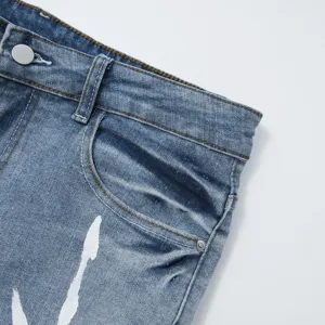 Dettaglio pantaloncini di jeans stretch uomo, bermuda blu con schizzi di vernice.