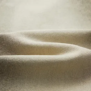 Detailed macro shot of premium khaki twill fabric showing clear texture and folds.