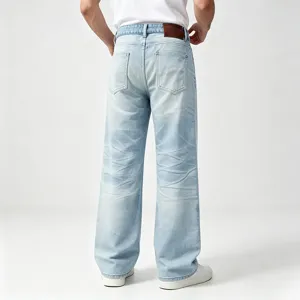 Jeans in denim dritti lavati azzurri da uomo con dettagli baffati e toppa in pelle posteriore.
