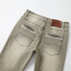 Men's slim straight vintage stretch denim jeans detail view with leather patch pocket.