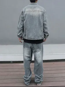Back view detail of men's washed denim jacket and loose straight pants set with monogram.