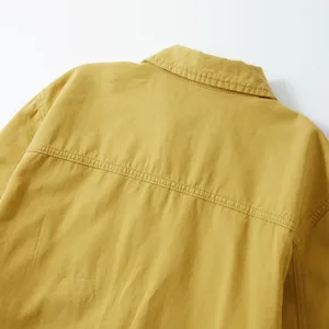 Detalle camisa de denim algodón hombre casual, textura tela amarilla, diseño costura espalda.