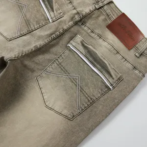 Close-up of men's vintage washed denim jeans back pocket, white stitching detail, leather patch