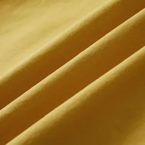 Detalle de tela de camisa de mezclilla de algodón con textura de sarga y color amarillo