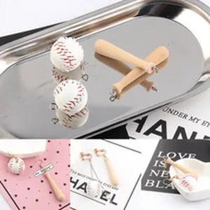 Gedetailleerd overzicht van mini honkbal en houten knuppel bedels voor DIY oorbellen.