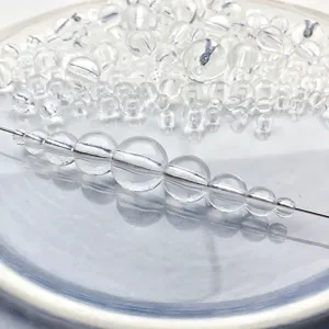 Clear transparent round acrylic beads detail showing sorted sizes for DIY jewelry crafting.