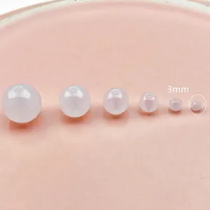 Transparent milky white acrylic round beads detail shot showing size comparison for DIY crafts.