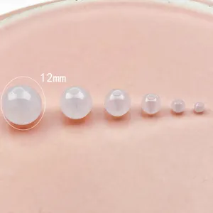 Detailed close-up of milky white acrylic round beads with straight holes in size comparison.