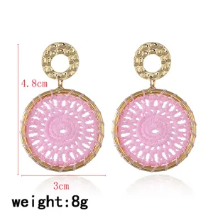 Bohemian woven pink circle earrings detail, featuring gold hammered ring and handmade design.