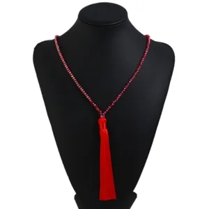 Red crystal beaded long necklace detail showing vibrant red tassel and shiny beaded chain design.
