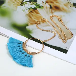 Lange goldfarbene Kette mit elegantem runden Ring und leuchtend blauen Quasten Anhängern.