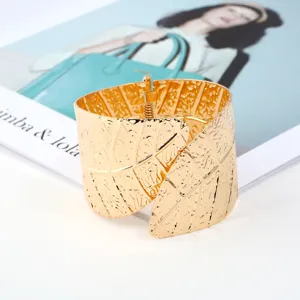 Detailed view of the wide gold plated metal leaf cuff bracelet, highlighting unique patterns.