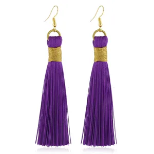 Detailaufnahme langer, böhmischer violetter Quasten-Ohrringe mit Goldwicklung für Damen.