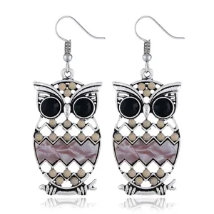 Pendientes colgantes de buho plateados con ojos de resina negra y detalles muy coloridos.