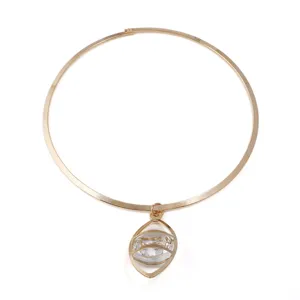 Nahaufnahme Detail einer vergoldeten Metall-Choker-Halskette mit Hohlauge-Kristall-Anhänger.