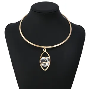 Nahaufnahme des goldfarbenen Metall-Chokers mit geometrischem Augenanhänger und klarem Kristall.